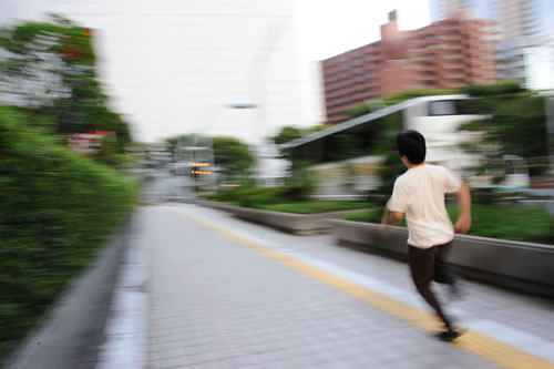 新宿のビル街を駆け抜けていくwosa記者