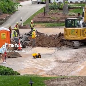 子供のおもちゃのダンプに作業中のショベルカーがサービスで土を入れてくれ、男の子は大喜び