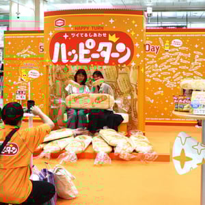 亀田製菓 ハッピーターン の世界に沼るパワスポ 5/22〜5/29 ＠東京駅に爆誕！ 抱き枕サイズのハッピターンといっしょに写真撮影、ちょいハピ展やプレゼント＆試食もあるぞーっ♪♪