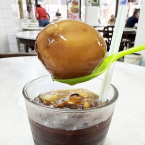 玉子入りアイスティーの卵を食べながらアイスティーを飲む / 名物料理として大人気